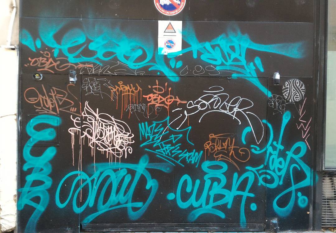 tags sur une porte réalisés à la bombe de peinture