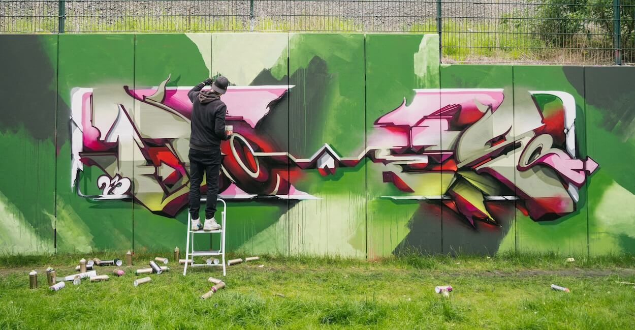 le graffeur DOES au travail sur un lettrage