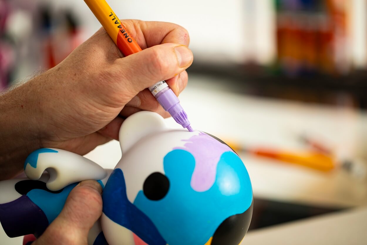 personnalisation d'une figurine en plastique à l'aide de feutres à peinture